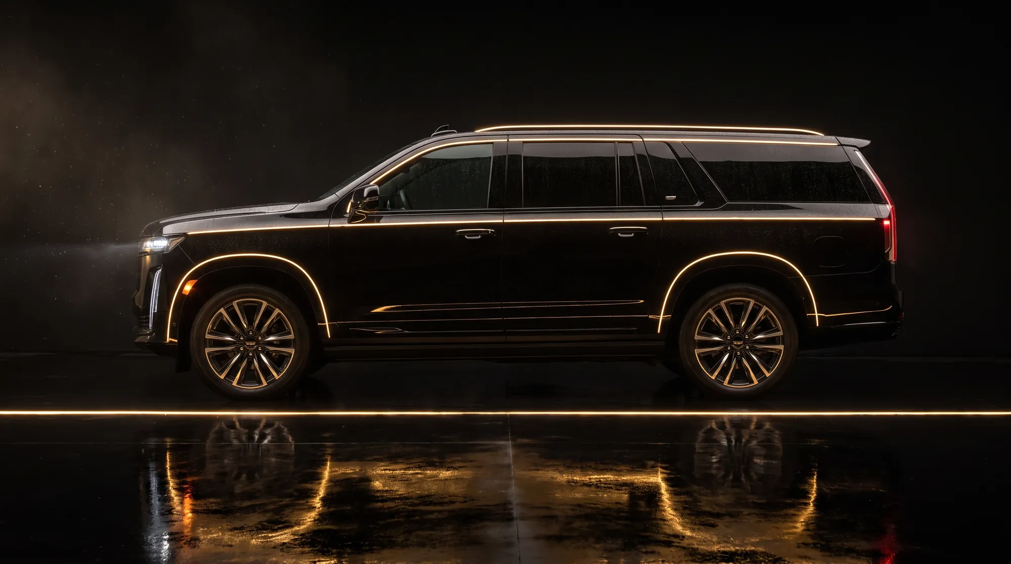 Black Cadillac Escalade ESV in profile, outlined by gold light on a dark wet floor
